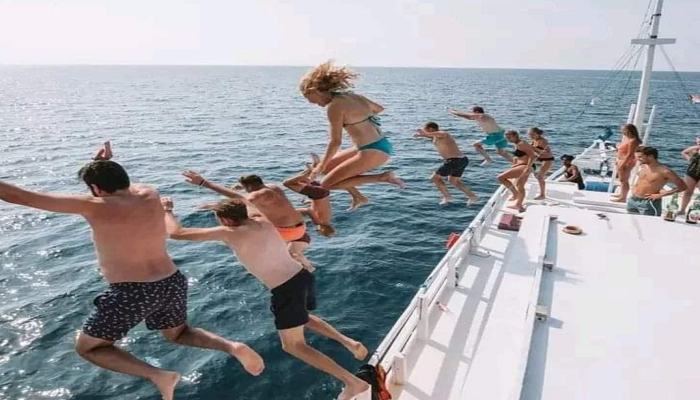 Jump the boat, adventure seeker, Adventurer diving into clear Komodo waters from boat, padar, komodo boat trip, Komodo adventure tour, diving Komodo, Padar hike tour