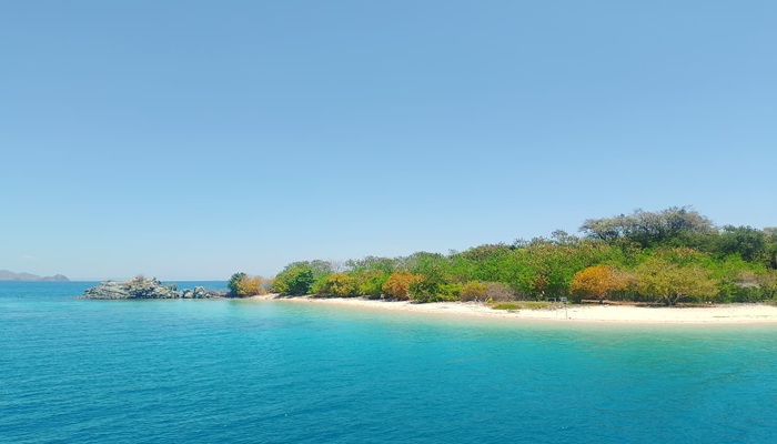 Aerial view of Bidadari Island near Labuan Bajo with turquoise waters, white sand beach, and lush green forest
