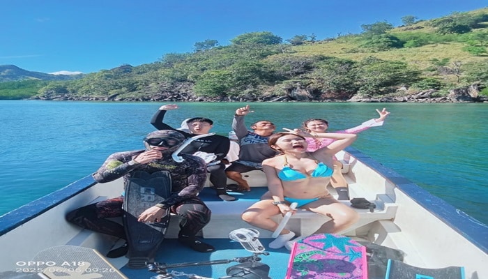 Siaba Island Komodo tours, white sand beach, snorkelers, Komodo Dragon Island Indonesia.