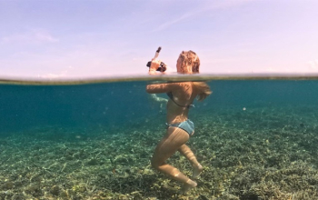 Luxury Phinisi boat sailing past Padar Island at sunrise during a Komodo boat tour 3 days 2 nights.
